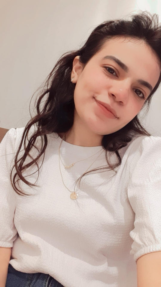 Woman wearing a white shirt with a plain background